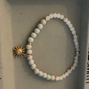 A sun bracelet with green rubber beads and white crystal beads